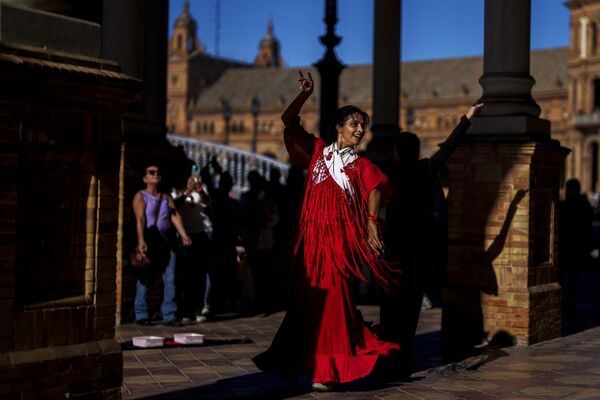 Женщина танцует фламенко и просит денег на площади Испании в Севилье, на юге Испании, воскресенье, 12 ноября 2023 года. - Sputnik Молдова