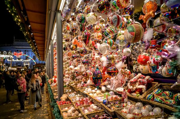 Vizitatorii privesc decorațiunile de Crăciun afișate la un stand de la Târgul de Crăciun din fața Primăriei din Viena, Austria, 14 noiembrie 2023.  - Sputnik Moldova