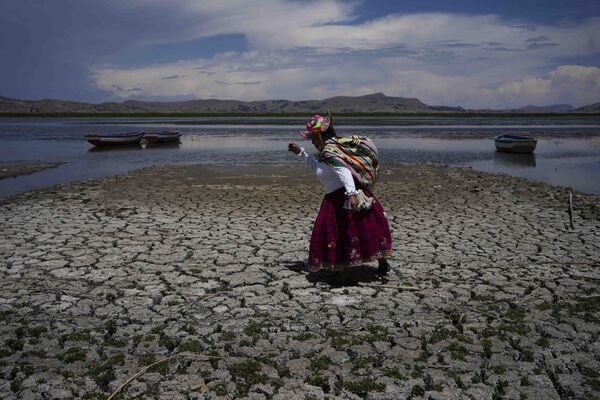 Женщина прогуливается по высохшему участку озера Титикака, Перу - Sputnik Молдова