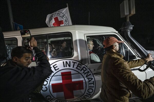 Автомобиль Красного Креста с израильскими заложниками проезжает мимо пункта пропуска в Рафахе, Палестина - Sputnik Молдова