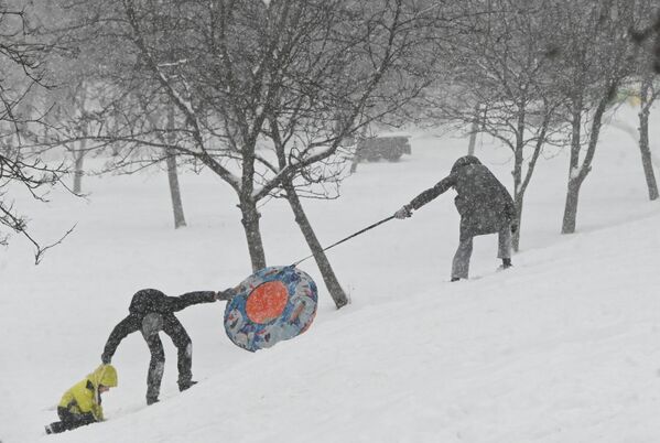 Люди катаются на тюбинге на Ленинском проспекте в Москве во время сильного снегопада. По данным метеорологов, высота снежного покрова может вырасти до 28 – 33 сантиметров. - Sputnik Молдова