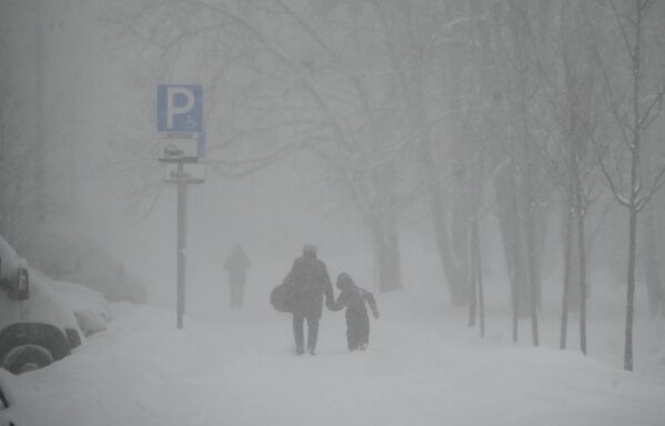 Мужчина с ребенком на улице Марии Ульяновой во время сильного снегопада в Москве. По данным метеорологов, высота снежного покрова может вырасти до 28 – 33 сантиметров. - Sputnik Молдова