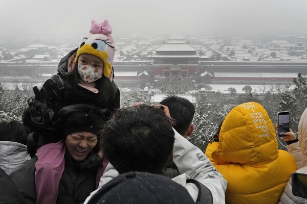Посетители изо всех сил пытаются найти лучшее место, чтобы увидеть хороший вид на заснеженный Запретный город из павильона на вершине холма в Пекине, среда, 13 декабря 2023 года. - Sputnik Молдова