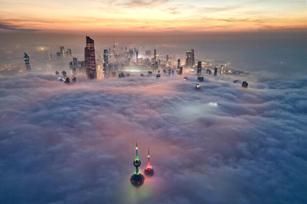 Знаменитые башни Кувейта и другие небоскребы прорываются сквозь облачный покров над городом Кувейт, 10 декабря 2023 года. - Sputnik Молдова