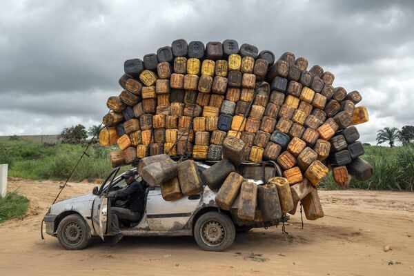Водитель с пустыми пластиковыми контейнерами останавливается по пути, чтобы купить топливо в Анголе, Демократическая Республика Конго - Sputnik Молдова