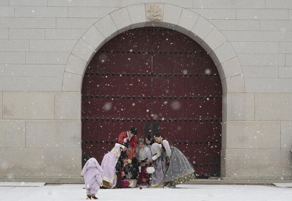 Женщины в традиционном южнокорейском костюме &quot;Ханбок&quot; делают селфи на снегу перед Кванхвамуном, главными воротами дворца Кёнбок XIV века, одной из известных достопримечательностей Южной Кореи в Сеуле. - Sputnik Молдова