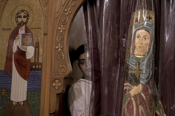 Коптский христианин выглядывает из окна во время православной рождественской мессы в церкви Авы Бишой и святого Караса Анахорета в Каире, Египет. - Sputnik Молдова