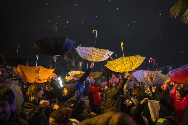 Люди поднимают зонтики, чтобы получить конфеты во время парада Крещения &quot;Кабальгата де Рейес&quot; в Барселоне, Испания. - Sputnik Молдова