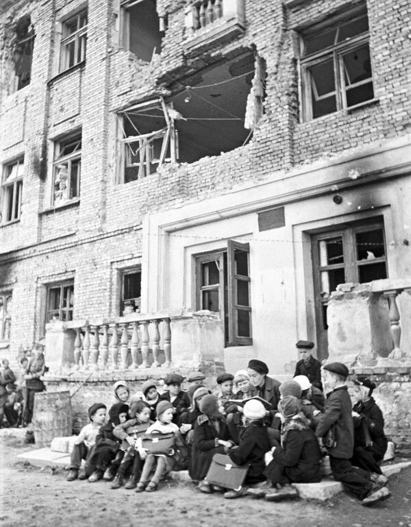 Урок на крыльце разрушенной немецкими обстрелами школы. - Sputnik Молдова