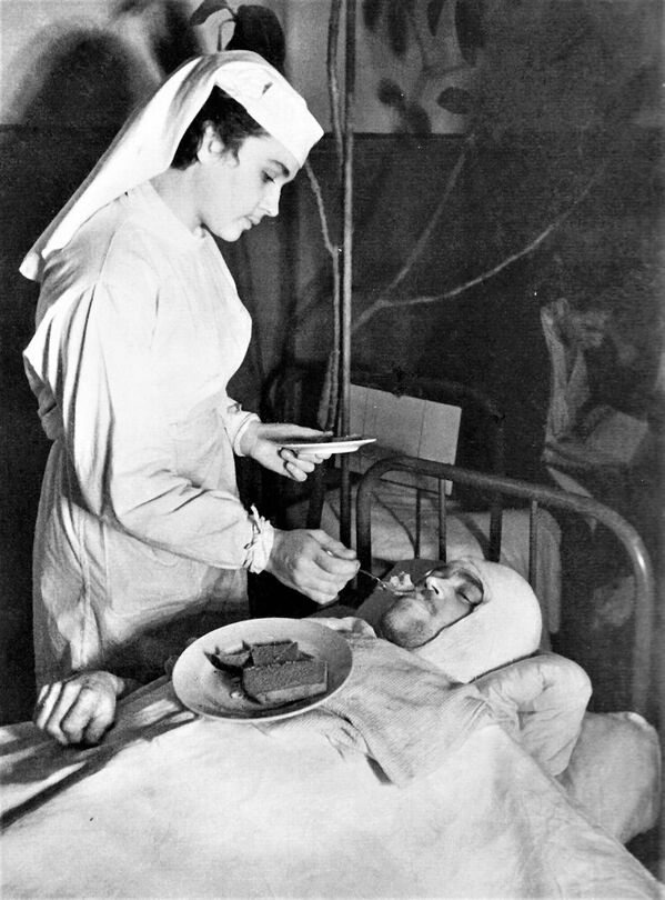 Медсестра Ленинградского Военно-морского госпиталя Анна Юшкевич кормит раненого краснофлотца - Sputnik Молдова