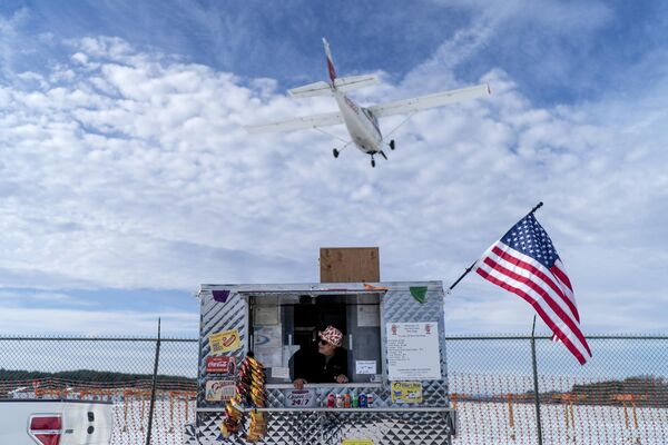 Продавец наблюдает, как самолет приземляется над его ларьком с хот-догами рядом с аэропортом, пока он ждет клиентов, Нашуа, штат Нью-Хэмпшир, США - Sputnik Молдова