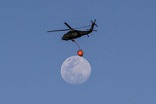 Вертолет Вооруженных сил загружает воду для тушения лесных пожаров в Боготе, Колумбия - Sputnik Молдова
