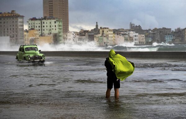 Турист фотографирует наводнение на Малеконе из-за холодного фронта в Гаване. - Sputnik Молдова
