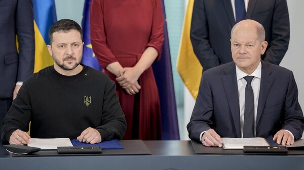 Președintele ucrainean Volodymyr Zelensky și cancelarul german Olaf Scholz în timpul semnării unui acord bilateral privind garanțiile de securitate - Sputnik Moldova