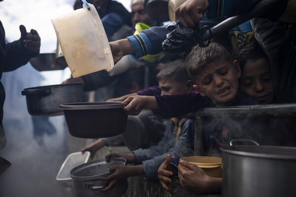 Палестинцы в очереди за бесплатным обедом в городе Рафах сектора Газа. - Sputnik Молдова