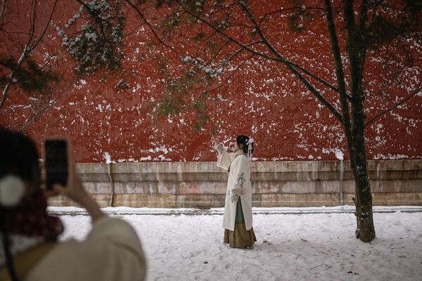 Женщина в традиционном костюме позирует в Запретном городе на следующий день после снегопада в Пекине - Sputnik Молдова