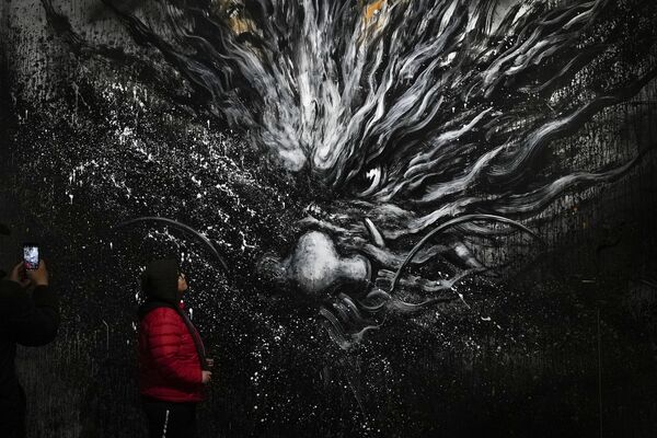 Женщина рядом с изображением дракона в арт-квартале Пекина, Китай - Sputnik Молдова