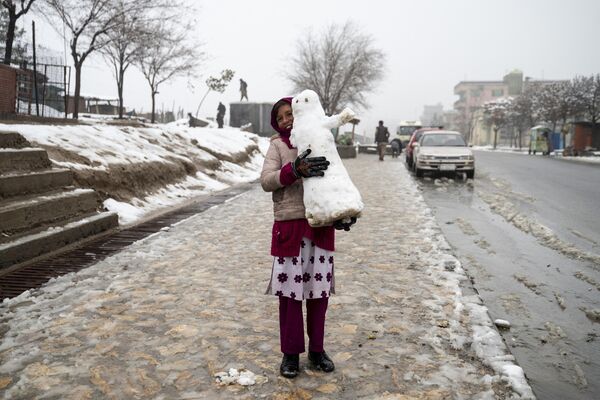 Девочка несет снеговика по заснеженному тротуару в Кабуле, Афганистан - Sputnik Молдова