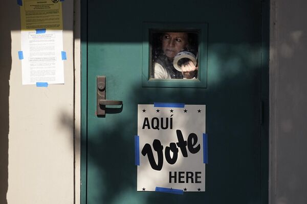 Женщина выглядывает из окошка избирательного участка в Сан-Антонио, США - Sputnik Молдова