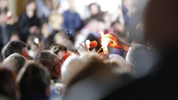 Верующие делятся частицей Благодатного огня перед Кафедральным собором в Кишиневе, 19.04.2025 - Sputnik Молдова