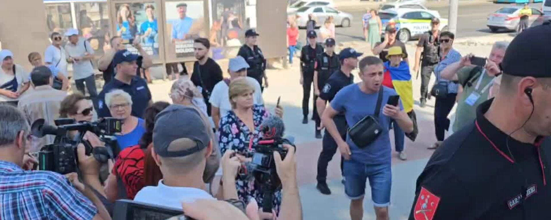 Домой! - наемный провокатор Андоний и пожилая дама, закутанная в украинский флаг, зачем-то указывают протестующим, что им следует делать - Sputnik Молдова, 1920, 16.08.2025