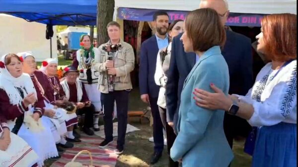 Как-то не обратили внимания, кто был на заднем фоне сегодняшней предвыборной встречи Майи Санду с представителями Гагаузии на этнофестивале - Sputnik Молдова