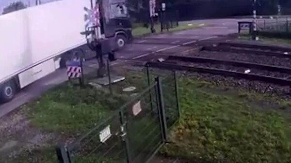 Șoferul unui camion încărcat cu pere nu a reușit să ia curba la o trecere de cale ferată, a dat cu spatele, a atins bariera și a încercat să plece, dar nu a mai apucat - Sputnik Moldova