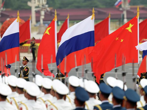 Почетный караул Народно-освободительной армии Китая (НОА) держат китайские и российские флаги перед церемонией приветствия президента России. - Sputnik Молдова