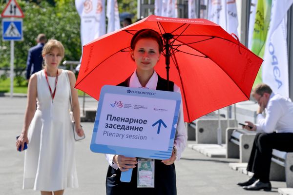 Волонтер встречает гостей с указателем к месту проведения пленарного заседания ВЭФ-2026. - Sputnik Молдова