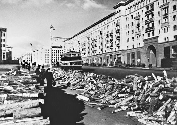 Прифронтовая Москва готовится к зиме. Заготовленные на зиму дрова на улице Горького. На дороге - троллейбус ЯТБ-3. - Sputnik Молдова