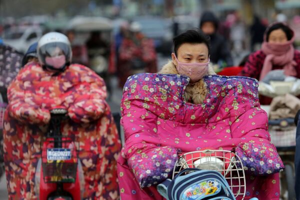 Жители города Ляньюньган, китайской провинции Цзянсу, в специальной одежде для езды на велосипедах и мотоциклах. - Sputnik Молдова