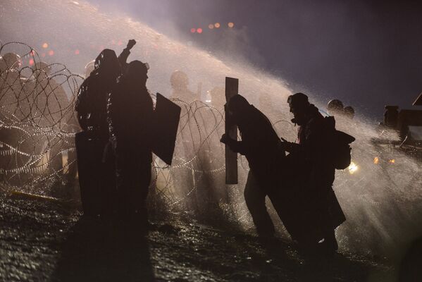 Порядка 400 протестующих против строительства нефтепровода столкнулись с сотрудниками полиции в Северной Дакоте 20 ноября. Полиция применила слезоточивый газ и водометы для разгона толпы. - Sputnik Молдова