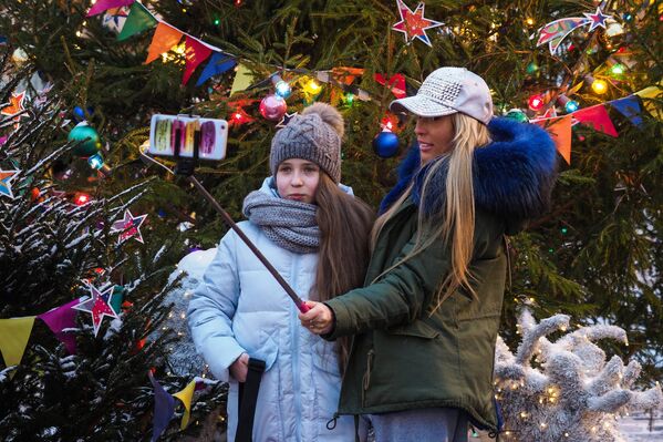 Tinerii fac poze în preajma bradului de Revelion din Piața Roșie - Sputnik Moldova-România