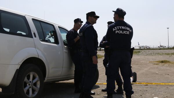 Cypriot policemen stand guard in the vicinity of Larnaca airport where an EgyptAir Airbus A-320 (R) sits on the tarmac after being hijacked and diverted to Cyprus on March 29, 2016 - Sputnik Moldova-România
