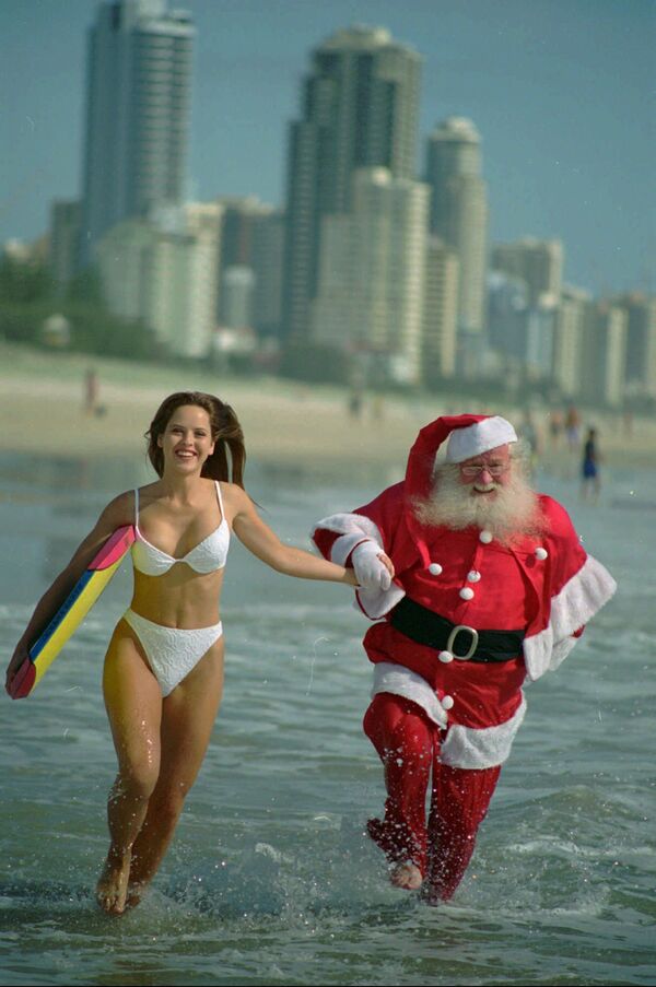 O australaină și Santa Claus la plaja din  Queensland, Australia. - Sputnik Moldova-România
