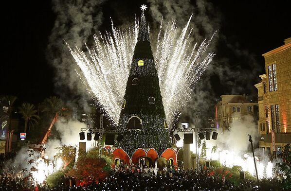 Фейерверки освещают небо пока новогодняя елка горит в ливанском прибрежном городе Библос, к северу от Бейрута. - Sputnik Молдова