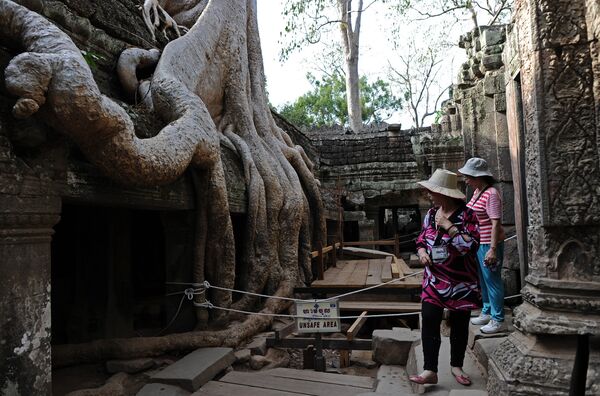 Această imagine a fost făcută pe 2 aprilie 2014, și prezintă turiști care vizitează templul Ta Prohm, parte a complexului arhitectural Angkor din nord-vestul Cambodgiei - Sputnik Moldova-România