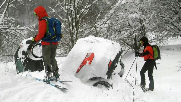 Members of Lazio's Alpine and Speleological Rescue Team are seen next to cars covered in snow in front of the Hotel Rigopiano in Farindola, central Italy, hit by an avalanche, in this January 19, 2017 handout picture provided by Lazio's Alpine and Speleological Rescue Team - Sputnik Moldova-România