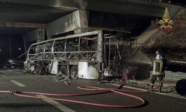 A firefighter sprays water on the burned hulk of a bus that crashed and burst into flames near Verona, northern Italy, Saturday, Jan. 21, 2017 A firefighter sprays water on the burned hulk of a bus that crashed and burst into flames near Verona, northern Italy, Saturday, Jan. 21, 2017 - Sputnik Moldova-România