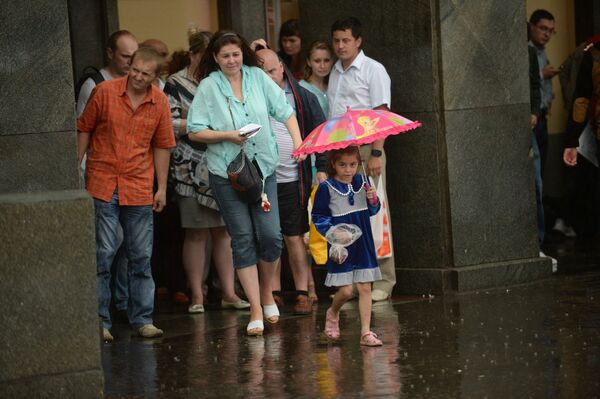Жители во время сильного дождя в Москве - Sputnik Молдова