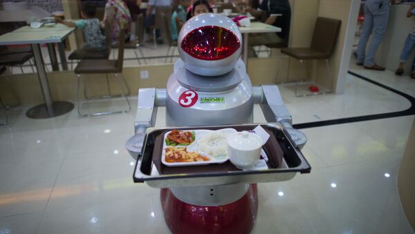 This photo taken on August 13, 2014, shows a robot carrying food to customers in a restaurant in Kunshan. It's more teatime than Terminator -- a restaurant in China is electrifying customers by using more than a dozen robots to cook and deliver food - Sputnik Moldova-România