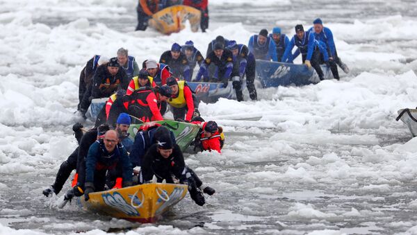Член команды Chez Victor падает в воду, во время гонки на льду на байдарках и каноэ в Квебек Зимний карнавал в Квебеке - Sputnik Moldova