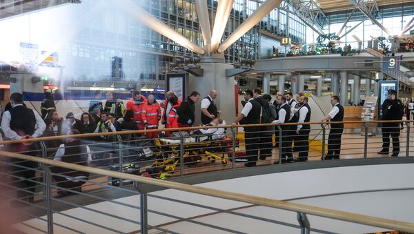Firefighters take care of a person on a stretcher inside Hamburg airport on February 12, 2017 in Hamburg, northern Germany, as German emergency services evacuated the airport after people reported an unusual smell as well as respiratory ailments and watering eyes - Sputnik Moldova-România