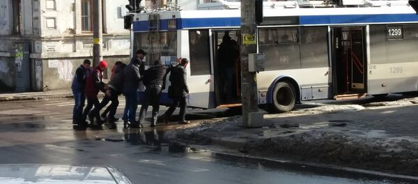 Пассажиры толкают троллейбус на пересечении улиц Букурешть-Бодони в Кишиневе Пассажиры толкают троллейбус на пересечении улиц Букурешть-Бодони в Кишиневе - Sputnik Молдова