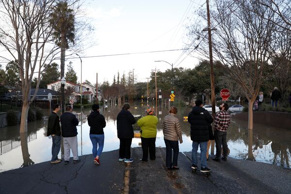 Люди стоят на затопленной улице Уильям Стрит Парк. Согласно прогнозам синоптиков, дожди в районе Сан-Хосе могут возобновиться. - Sputnik Молдова