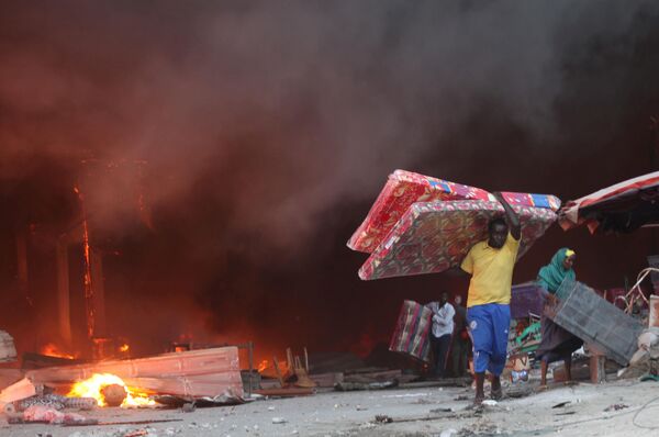 Торговцы спасают свое имущество во время пожара на главном рынке столицы Сомали Могадишо - Sputnik Молдова