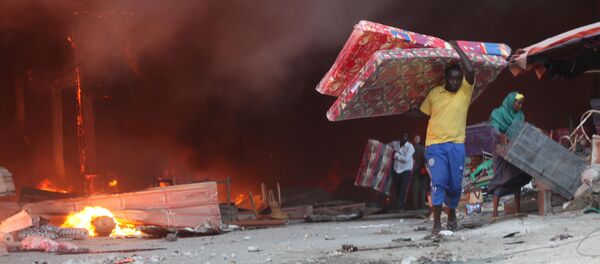 Торговцы спасают свое имущество во время пожара на главном рынке столицы Сомали Могадишо - Sputnik Молдова