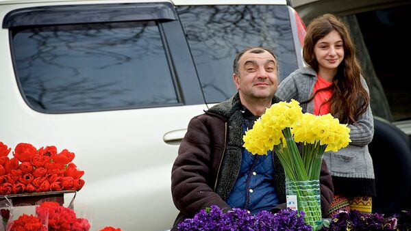 Мужчина, торгующий цветами на цветочном рынке, вместе со своей дочерью радуется празднику 8 марта. - Sputnik Молдова