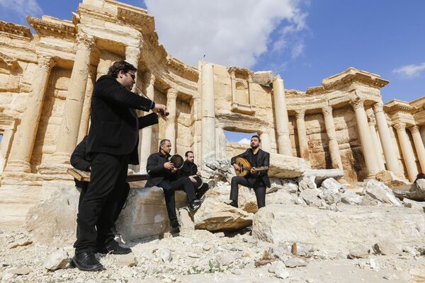 Сирийские музыканты играют у разрушенного римского амфитеатра в Пальмире - Sputnik Молдова