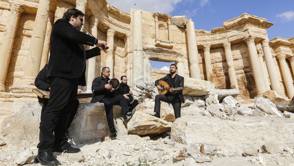 Сирийские музыканты играют у разрушенного римского амфитеатра в Пальмире - Sputnik Молдова